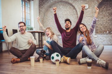 TV'de futbol izlerken ve evde zaferini kutluyor genç arkadaşlar