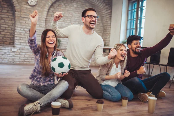 テレビでサッカーを見ていると ホームでの勝利を祝っての若い友人 — ストック写真