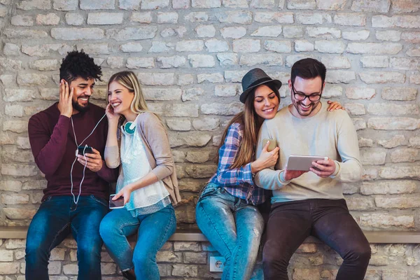 Two Young Couples Sitting Bench Using Different Devices — Stock Photo, Image