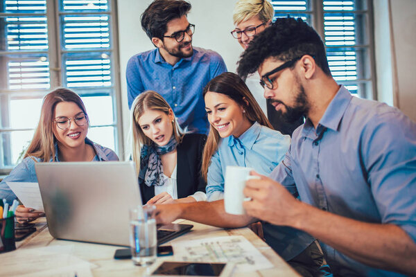 Молодые творческие коллеги обсуждают новый проект в офисе
