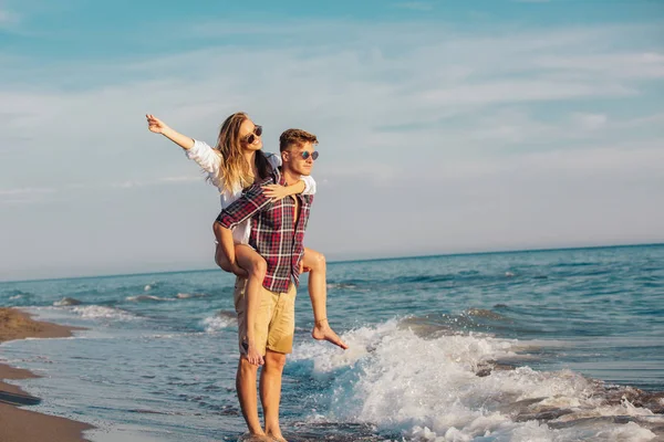 Joven Mujer Piggybacking Joven Novio Playa — Foto de Stock