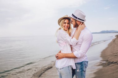 Eğleniyor kumsalda gün batımında romantik genç çift