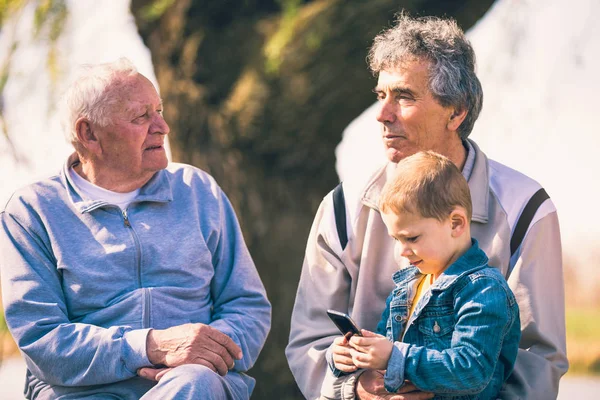 Twee Senior Mannen Kleinzoon Met Behulp Van Slimme Telefoon Het — Stockfoto