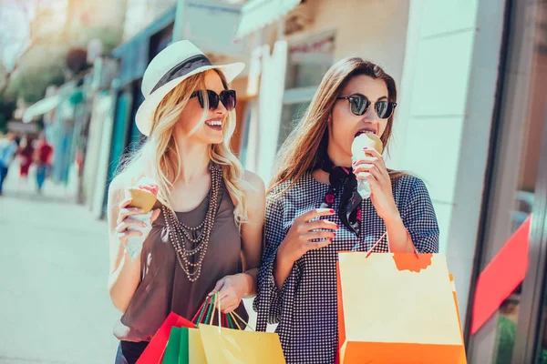 ショッピング バッグとアイスクリームの街上で楽しんで幸せな若い女性 — ストック写真