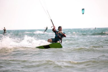 Cesur adam kitesurfing dalgalar arasında hızlı 