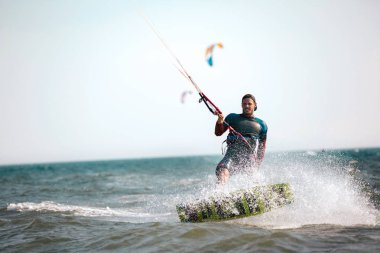 Cesur adam kitesurfing dalgalar arasında hızlı 