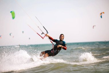Cesur adam kitesurfing dalgalar arasında hızlı 