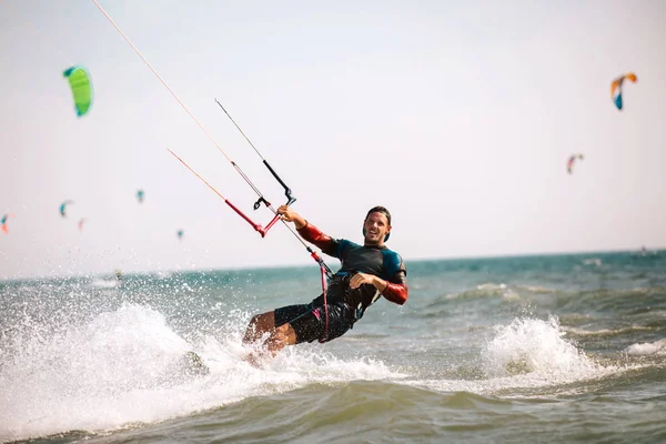 Brave man kitesurfing fast among waves