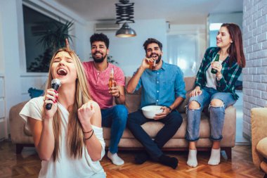 Bir grup arkadaş evde karaoke yapıyor..