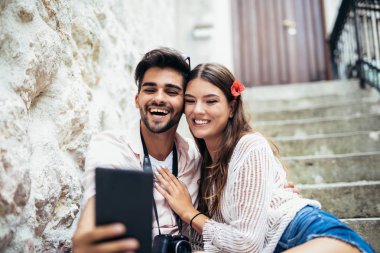 Merdivenlerde oturan ve tablet bilgisayar başında arıyor Romantik Çift