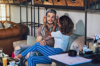 Kafede oturup, kahve içme ve müzik karışık yarış genç çift.