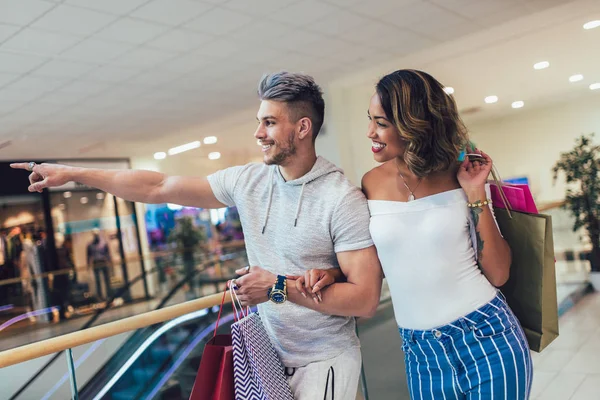 幸せな若いカップルがモールを歩いて買い物袋 — ストック写真
