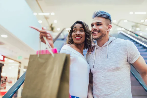 幸せな若いカップルがモールを歩いて買い物袋 — ストック写真