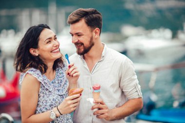 Gülümseyen çift tatilde dondurma yeme.