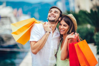 Renkli alışveriş torbaları Harbor turistik deniz tatil tekne ile arka plan üzerinde yürüme ile genç çift
