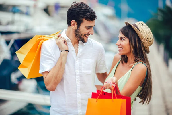 Renkli alışveriş torbaları Harbor turistik deniz tatil tekne ile arka plan üzerinde yürüme ile genç çift