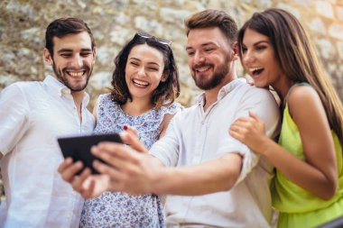Genç turist arkadaşlar eğlenmeye dijital tablet ile Grup