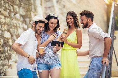 Genç turist arkadaşlar eğlenmeye dijital tablet ile Grup