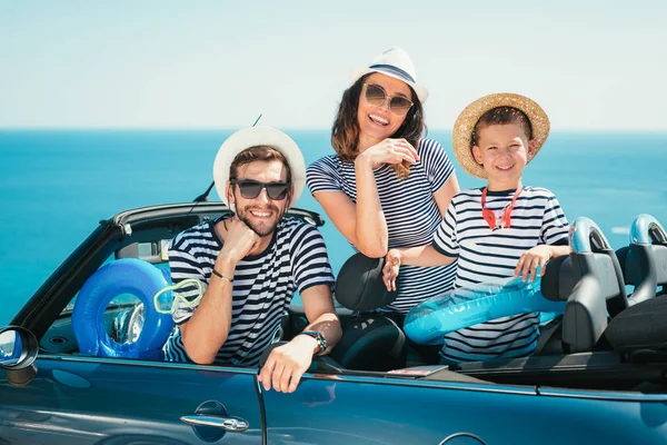 Happy family travel by car to the sea. People having fun in cabriolet. Summer vacation concept