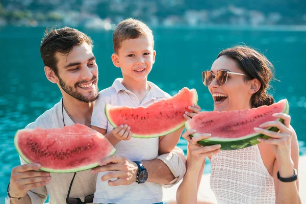 男孩与父母在海边乐趣和吃西瓜 — 图库照片