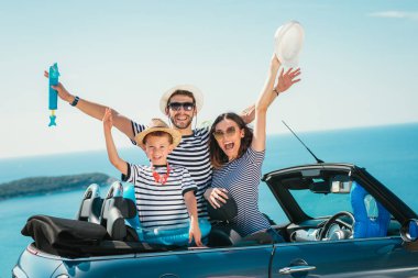 Mutlu aile seyahat ve sahip eğlenceli deniz kenarında cabriolet arabada
