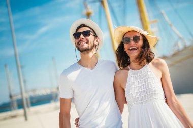 Genç çift Yelkenli ile liman tarafından arka plan üzerinde yürüme