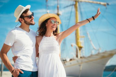 Genç çift Yelkenli ile liman tarafından arka plan üzerinde yürüme