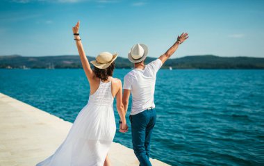 Genç gülümseyen iki yürüyor ve sahil üzerinde gülüyor