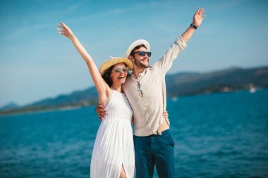 Genç gülümseyen iki yürüyor ve sahil üzerinde gülüyor