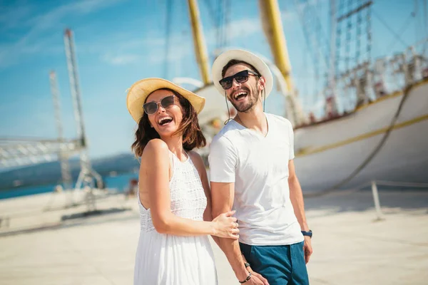 Genç çift Yelkenli ile liman tarafından arka plan üzerinde yürüme