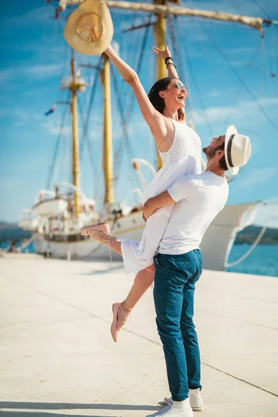 Genç çift Yelkenli ile liman tarafından arka plan üzerinde yürüme