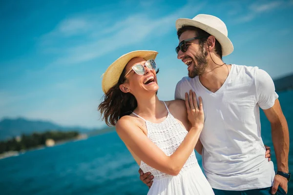 Genç gülümseyen iki yürüyor ve sahil üzerinde gülüyor