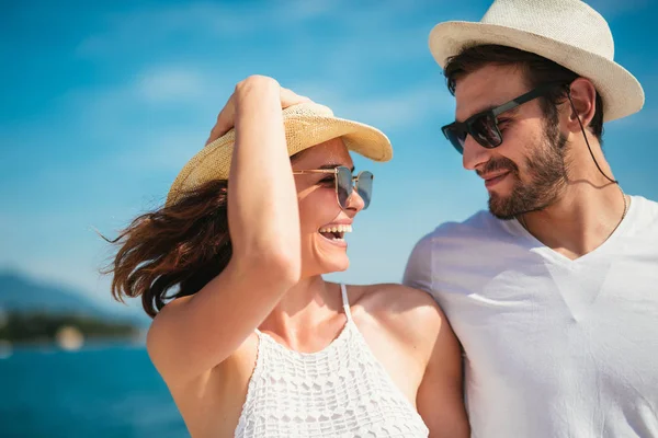 Genç gülümseyen iki yürüyor ve sahil üzerinde gülüyor