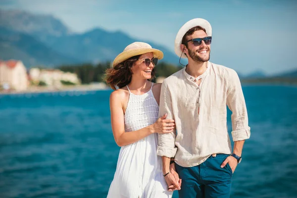 Genç gülümseyen iki yürüyor ve sahil üzerinde gülüyor