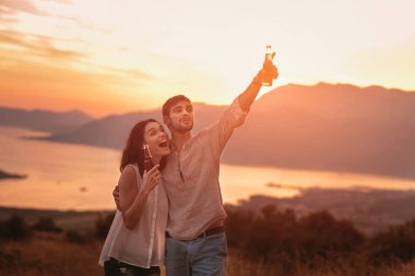 Boka körfezde günbatımında içki bira genç çift