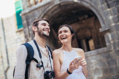 Eski şehir yürüyüş ve smartphone kullanarak turist çiftin seyahat