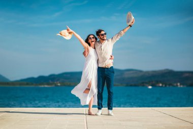 Genç gülümseyen iki yürüyor ve sahil üzerinde gülüyor