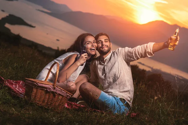 Ungt Par Som Har Det Gøy Piknik Ved Solnedgang Boka – stockfoto