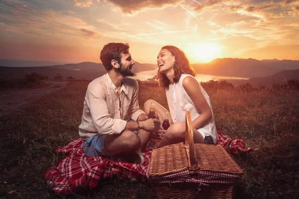 Genç çift pikniğe günbatımında Boka Körfezi eğleniyor