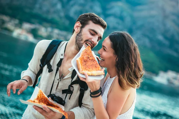 通りにピザを食べる観光客の幸せカップル — ストック写真