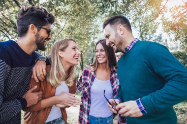 Bir grup genç parkta yürüyor. Arkadaşlar dışarıda eğleniyor.