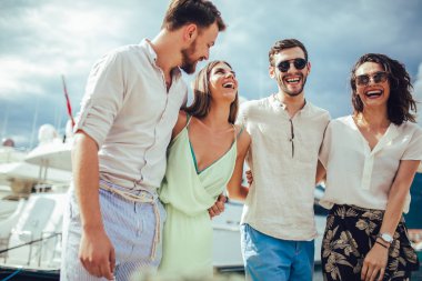 Bir turistik deniz tatil tekne ile liman tarafından arka planda yürüyen arkadaşlar