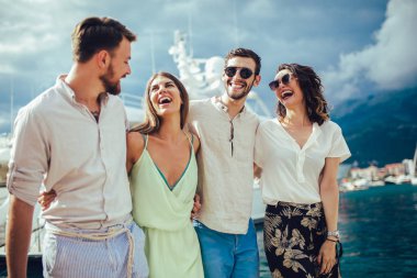 Bir turistik deniz tatil tekne ile liman tarafından arka planda yürüyen arkadaşlar