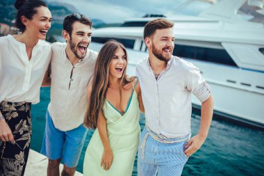 Bir turistik deniz tatil tekne ile liman tarafından arka planda yürüyen arkadaşlar