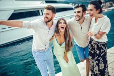 Bir turistik deniz tatil tekne ile liman tarafından arka planda yürüyen arkadaşlar