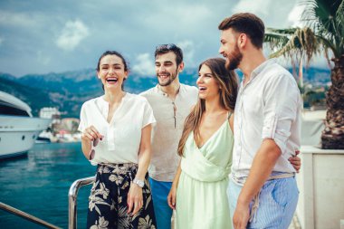 Bir turistik deniz tatil tekne ile liman tarafından arka planda yürüyen arkadaşlar