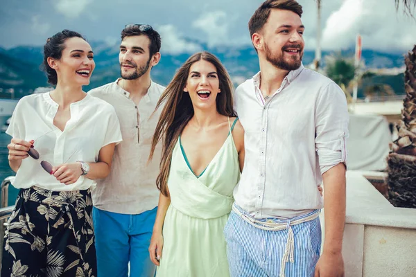 Bir turistik deniz tatil tekne ile liman tarafından arka planda yürüyen arkadaşlar