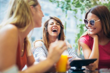 Üç güzel arkadaş bir kafe kullanarak tablet pc ve having fun