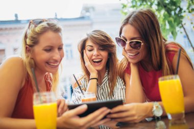 Üç güzel arkadaş bir kafe kullanarak tablet pc ve having fun