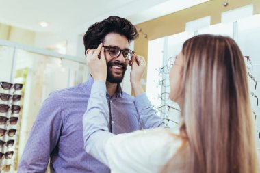 Optik merkezi müşteri için görsel muayene yaparken göz doktoru.